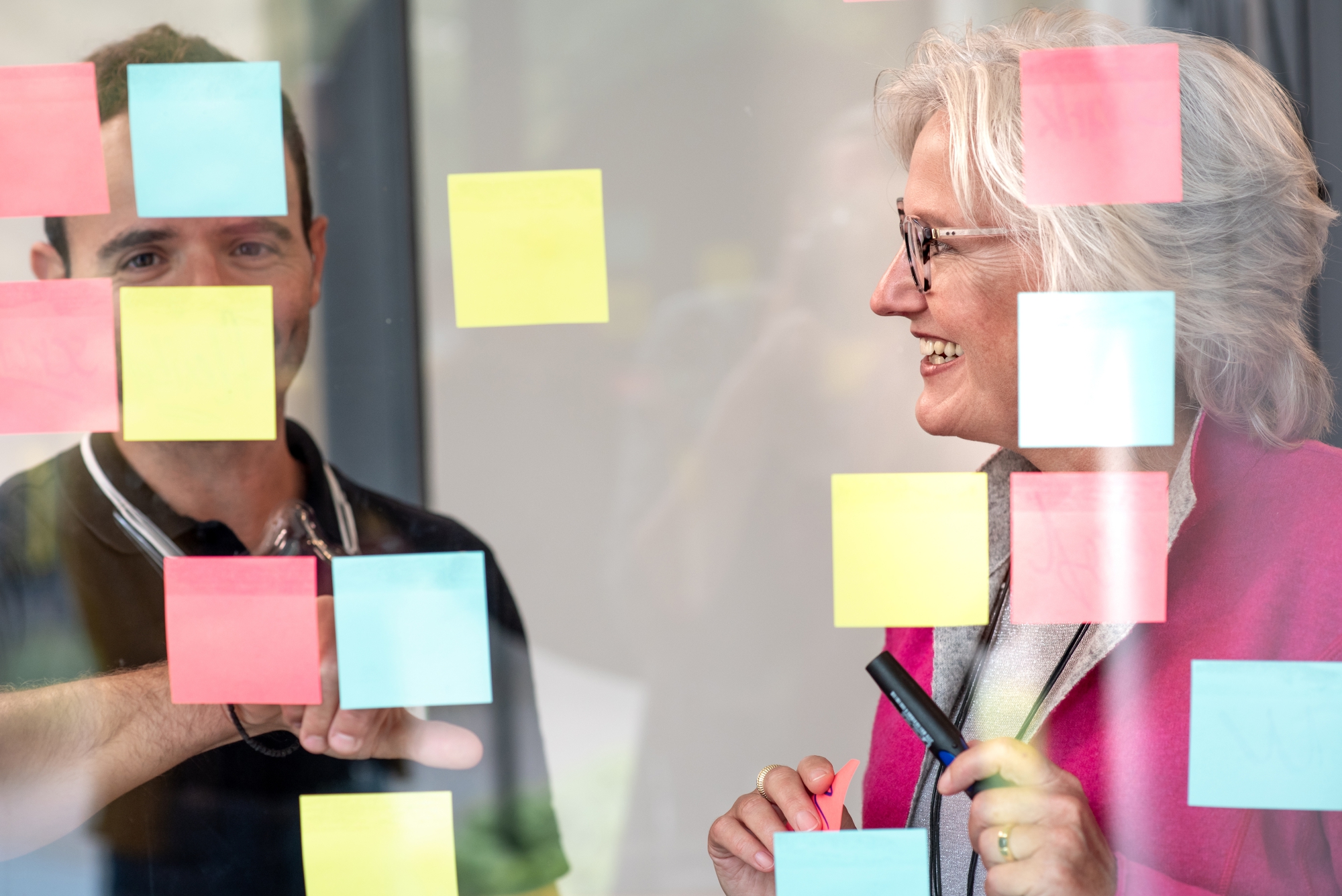 Rosemarie Spindler im Teamcoaching an einer Glaswand mit Haftnotizen
